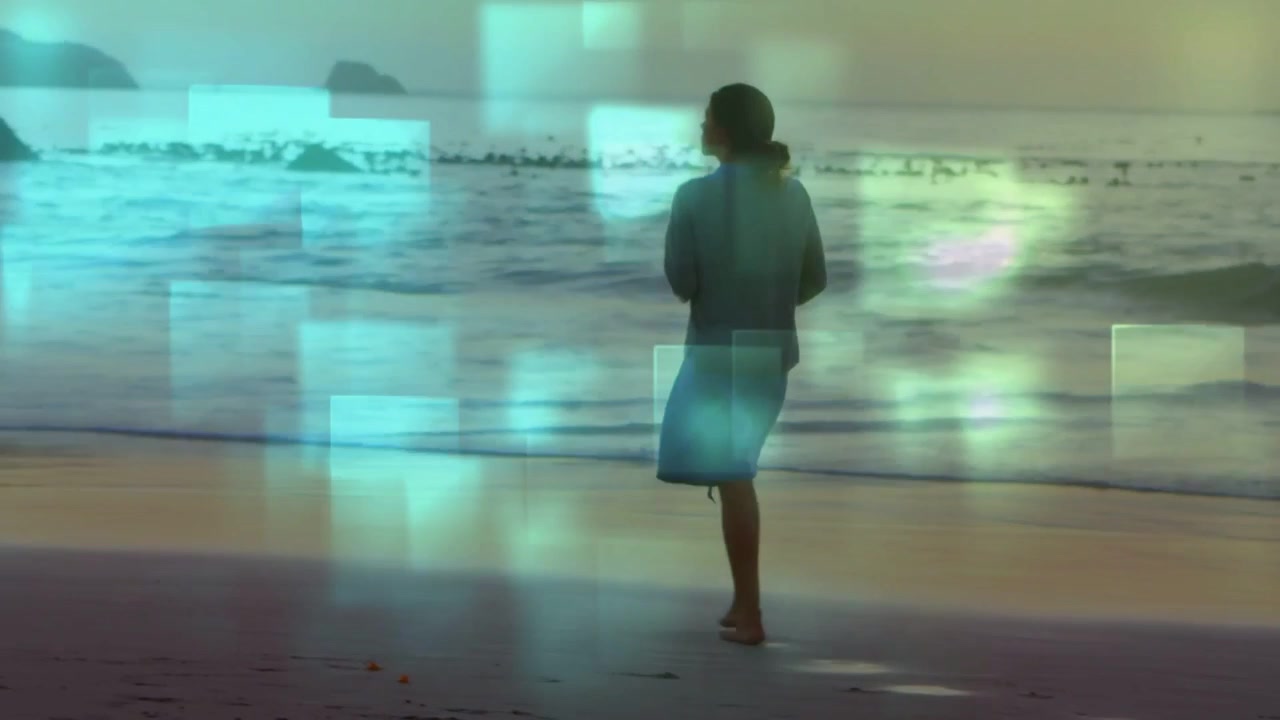 Camera panning low revealing woman walking shore teal overlay drifting, pausing watching sunrise