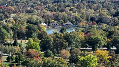 Luftaufnahme-Des-Bootshauses-Im-Waldpark-An-Einem-Schönen-Herbsttag-Mit-Einer-Neigung-Nach-Oben,-Um-Am-Horizont-Gebäude-Im-Zentralen-Westende-Freizulegen