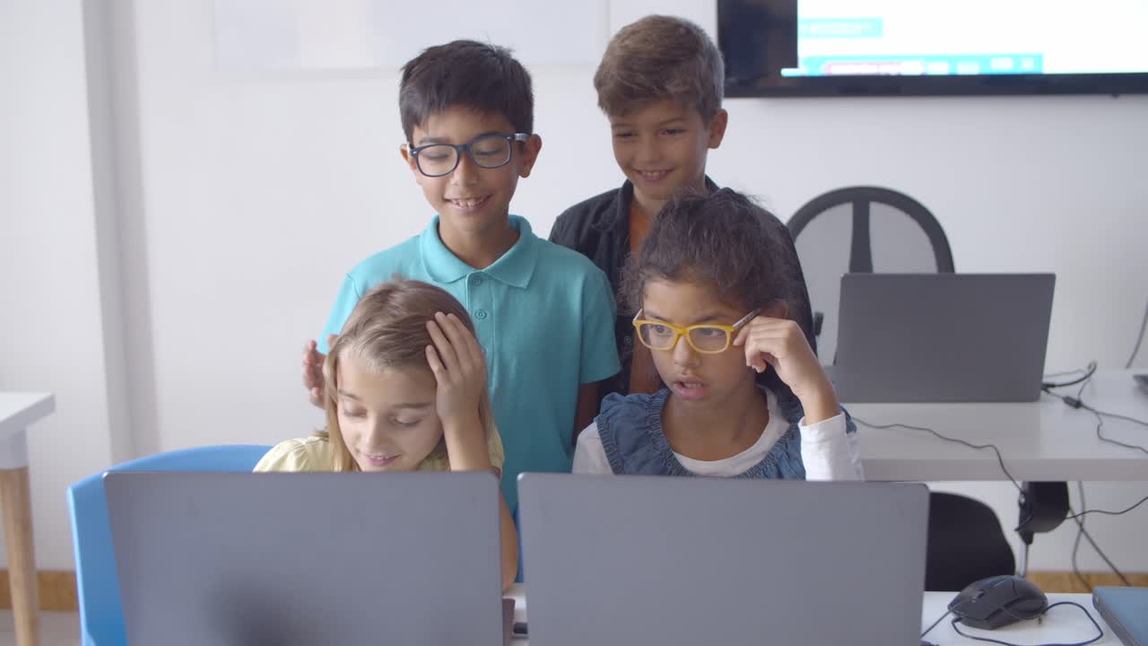 equipo de alumnos centrados sentados y de pie en el escritorio