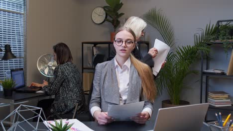 female business company manager sitting at office desk reading resume, successful job interview