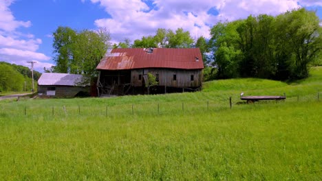 Antena-Baja-Del-Antiguo-Granero-Oxidado-Y-Equipo-Agrícola-Cerca-De-Mountain-City-Tennessee