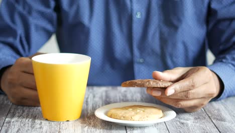 persona comiendo galletas con una taza de té