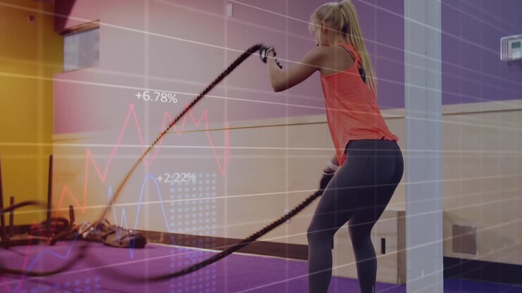 Animation of graphs over caucasian woman exercising at gym with ropes