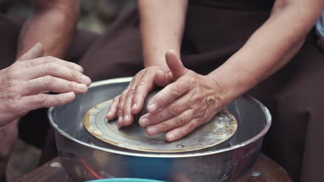 close up hands make pitchers in pottery