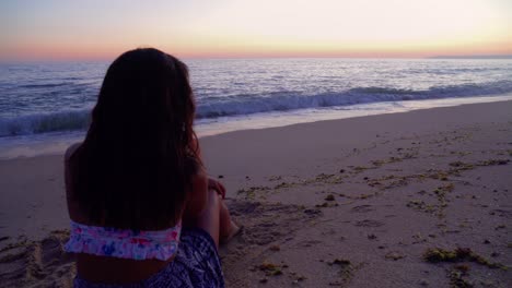 Mujer-Relajándose-En-La-Playa-Mirando-La-Puesta-De-Sol