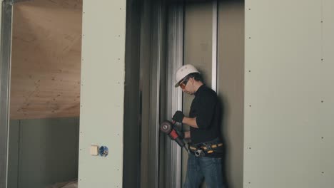 un hombre trabaja con una molienda angular en un casco y gafas de seguridad. video 4k.