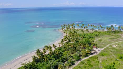 Vista-Aérea-Con-Vistas-A-Palmeras-Y-Aguas-Turquesas-Poco-Profundas-En-La-Playa-Costa-Esmeralda,-En-Miches,-Dr---órbita,-Disparo-De-Drones