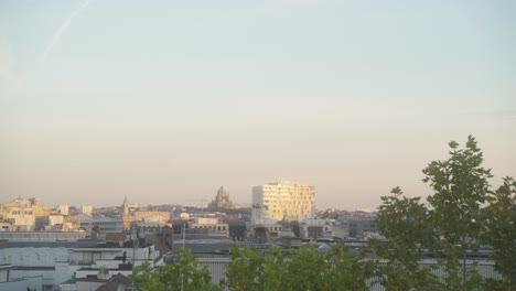 the skyline of the city of brussels, belgium, during sunset, with the koekelberg cathedral in the distance on the horizon