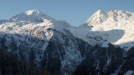 Drone-shot-showing-the-snow-covered-mountains-on-the-other-side-of-the-valley-during-the-last-available-sun-light