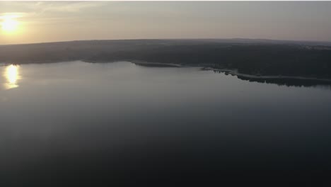 Wide-aerial-view-of-a-beautiful-sun-in-the-largest-dam-in-Portugal-in-Alentejo,-Alqueva