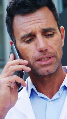 el médico habla por teléfono móvil.