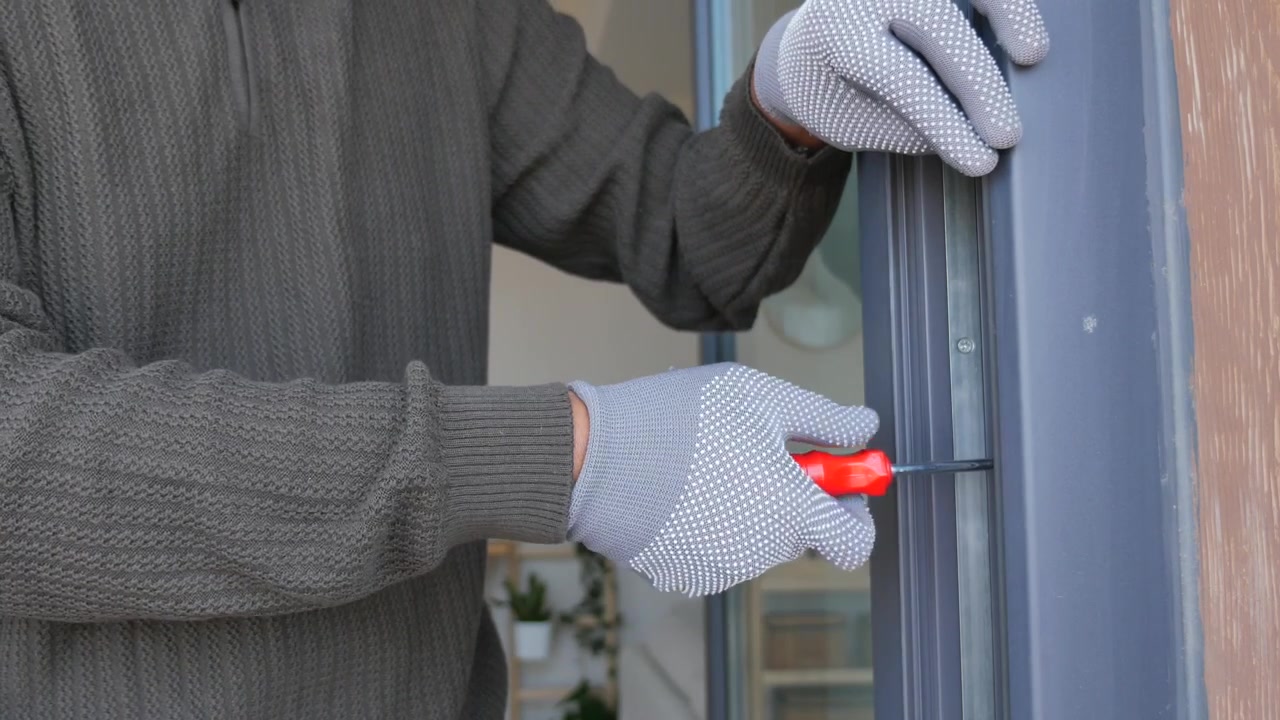 Handyman Using Screwdriver to Adjust Window Frame