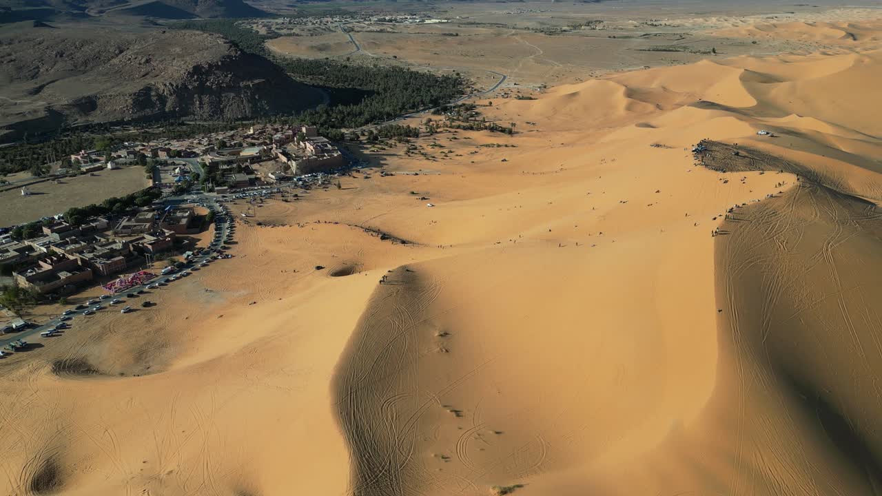 Taghit, a stunning oasis in Algeria's Sahara, blends golden dunes, lush palms, and traditional charm. Aerial views reveal its serene beauty and vibrant desert life.