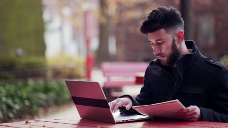a business man asked ballpen and cross-checking document into his laptop and write down important notes on significant information - close up shot