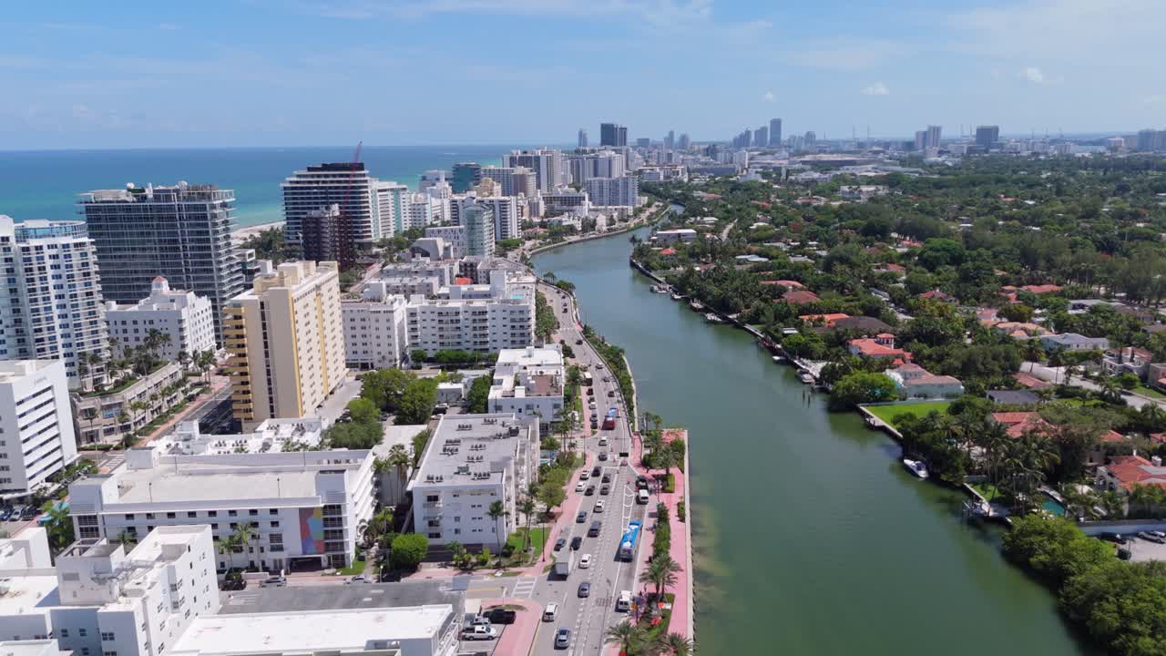 Miami Beach bridge, Indian Creek waterway, oceanfront hotels, downtown Miami skyline in background, Florida. Aerial forward
