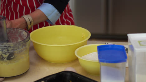 mujer con delantal rojo en la cocina, preparando albóndigas de patata eslovacas