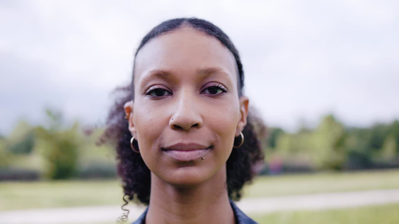 auténtica mujer joven latina mirando a la cámara al aire libre en el parque de la ciudad