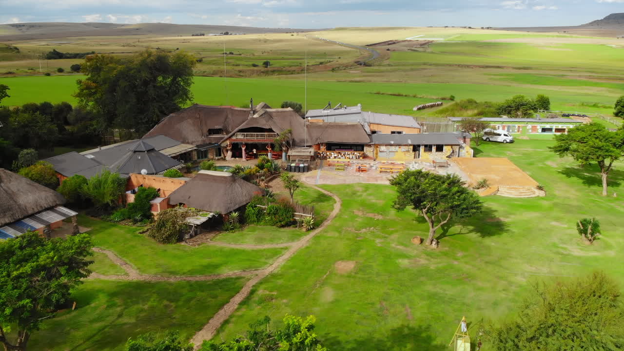 Aerial View of a Thatched-Roof Building in a Rural Landscape