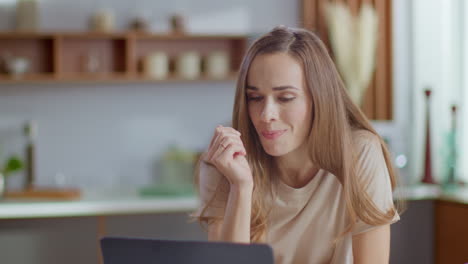 businesswoman using laptop at kitchen