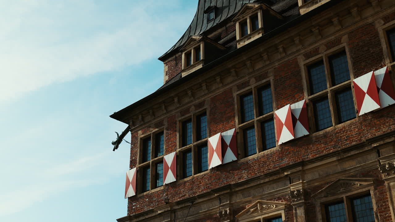 Brick facade and reflective windows of Schloss Raesfeld, showing traditional German architecture on a clear sunny day