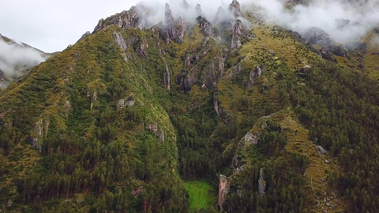 aéreo, en ascenso, toma de drones de montañas rocosas y verdes, cubiertas de niebla, en los andes, en un día nublado, cerca de cuzco, en perú