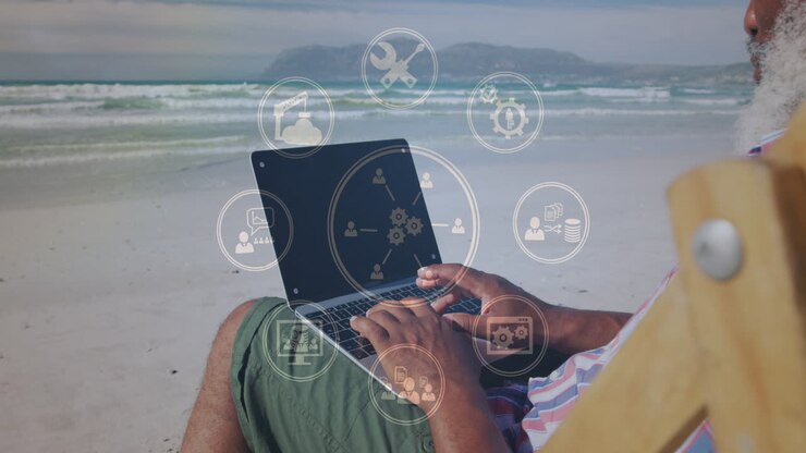 Animation af ikoner over ældre afroamerikansk mand, der bruger bærbar computer på solrig strand