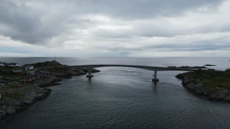 volando sobre el puente en el tradicional pueblo de pescadores hamnoy en lofoten, noruega con vistas al océano abierto y clásicas cabañas de pescadores rorbuer