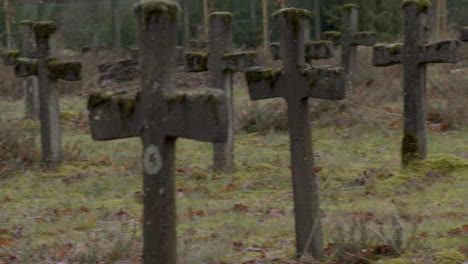 close pan over old gravestones in weed overgrown cemetery