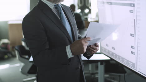 cropped bearded businessman reading documents with data