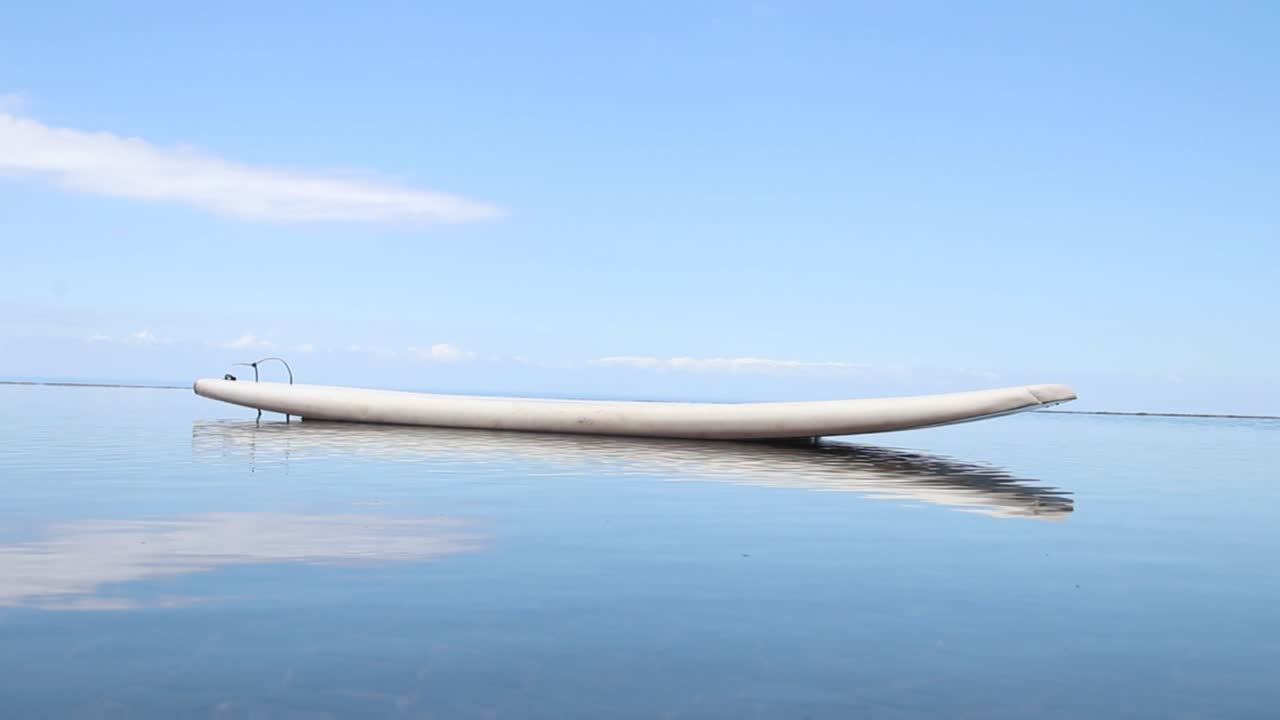 tabla de surf aislada en aguas tranquilas mañana clara amanecer cielo azul brisa de verano tranquilidad libre de estrés paz relajarse sin estrés relajarse zen buena salud comodidad seguridad protección prosperidad