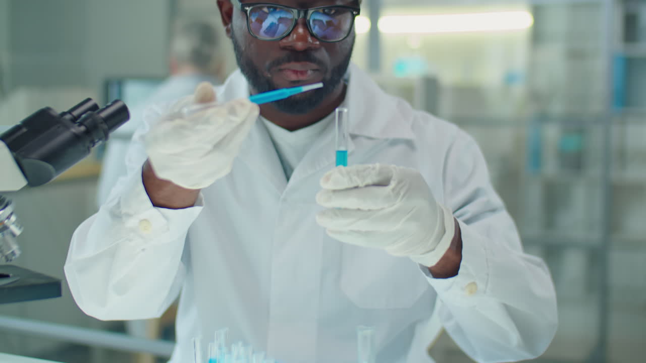 African American Scientist Working Blue Chemical in Lab