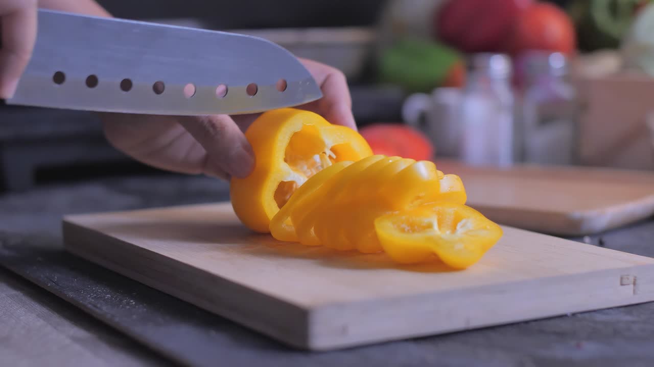 절단판에 가까이 잘라진 노란 고추를 넣습니다.