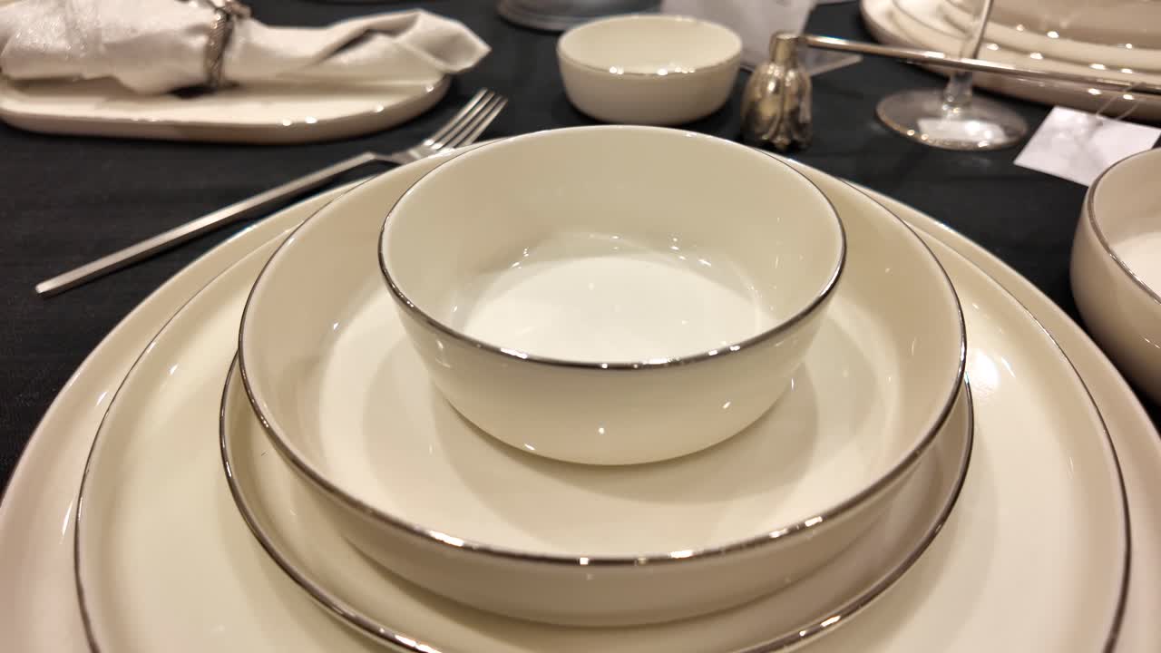 Elegant White Dinnerware Set with Silver Rim on a Dark Table