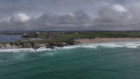 aerial panning shot showing fistral beach, the headlands hotel and towan headland