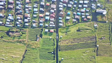 perspectiva aérea de una aldea flotante en el lago inle, myanmar, con casas en vías fluviales rodeadas de exuberantes tierras de cultivo verdes y canales organizados, que muestran la vida rural y la vida sostenible