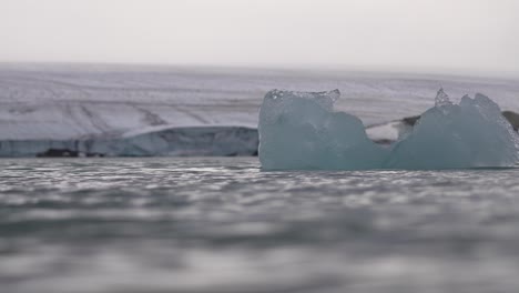 Hielo-Flotante-En-Agua-De-Mar-Fría-Bajo-El-Glaciar,-Cámara-Lenta-Cinematográfica-De-ángulo-Bajo