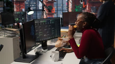 mujer usando computadora en la agencia de desarrollo de inteligencia artificial, comiendo comida