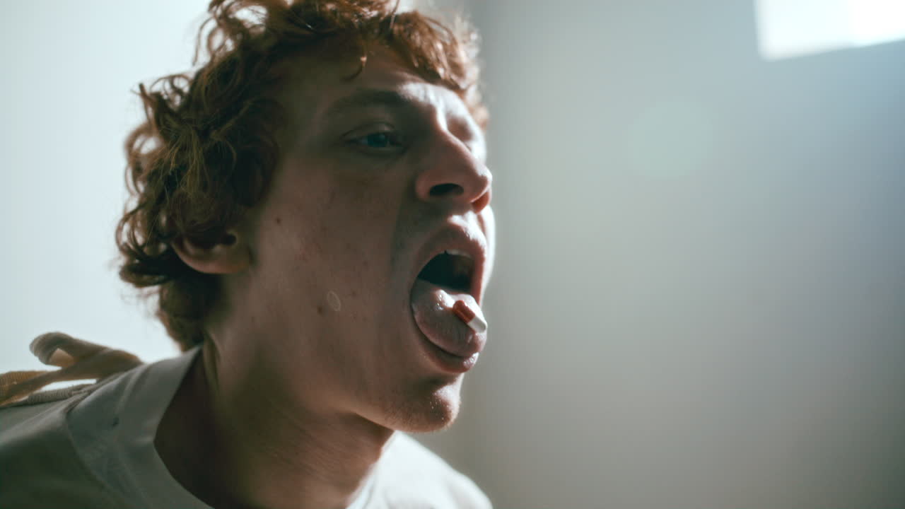 Psychiatric Patient Showing Pill on His Tongue while Taking Medication