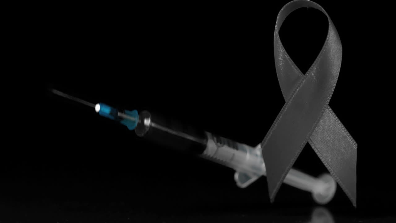 Syringe falling near red ribbon 