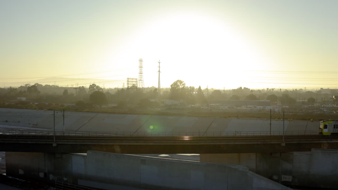 Tren de metro pasando por un paisaje urbano al atardecer