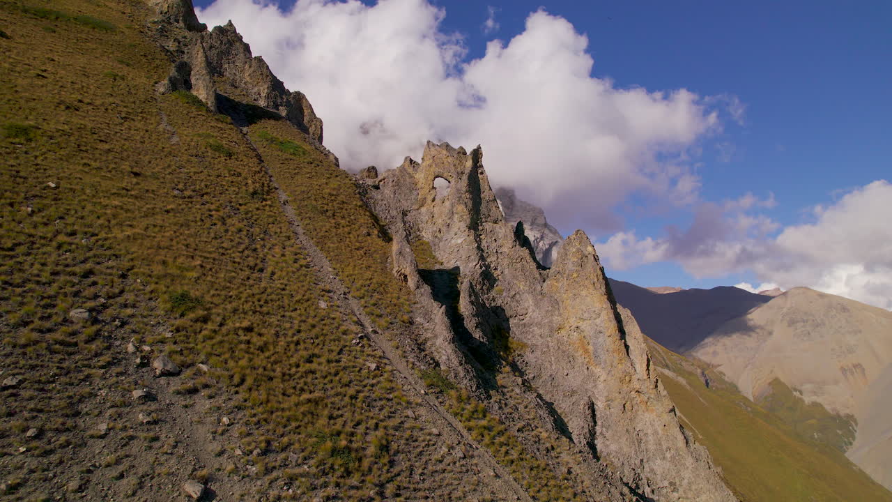 Trekking trail toward World's highest lake Tilicho at Manang Nepal, Unique and weird structure at hills with algae under the blue sky-covered clouds drone shot 4K