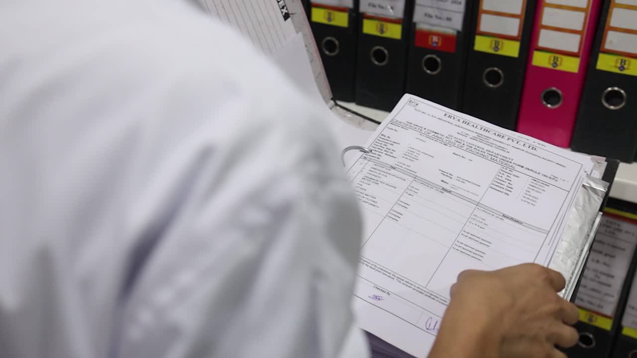 Woman in White Coat Organizing Medical Files and Inventory