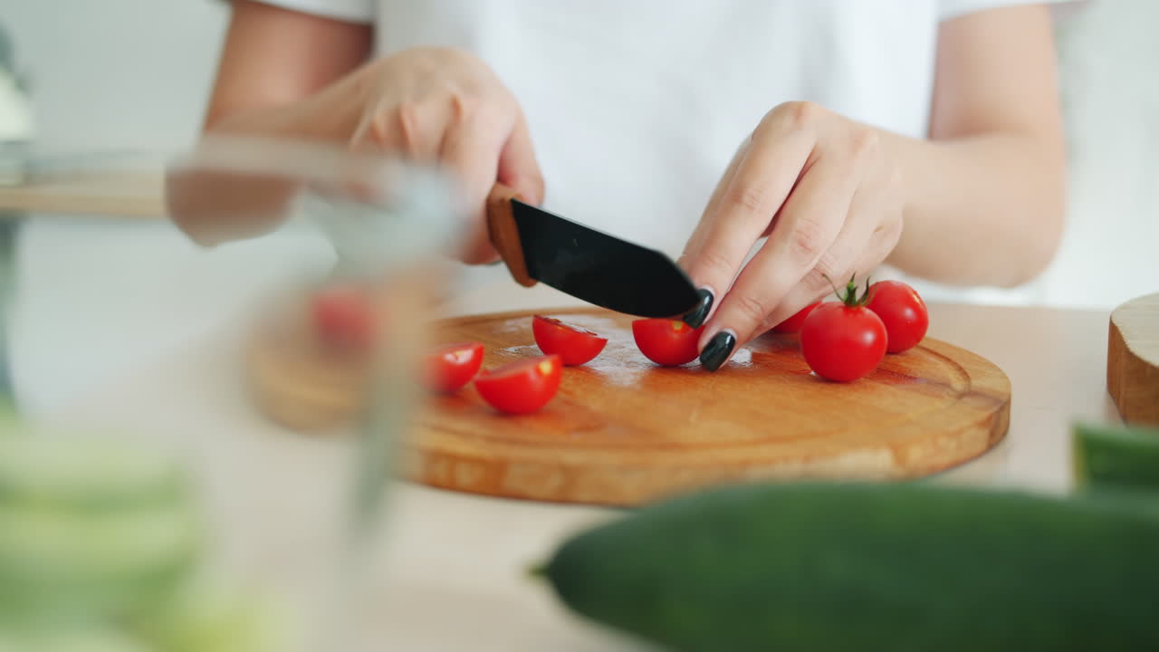 Woman chopping cherry tomatoes