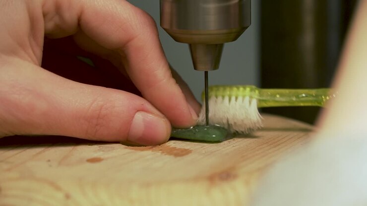 Close up of drilling hole into greenstone from New Zealand and cooling drill with water on tooth brush