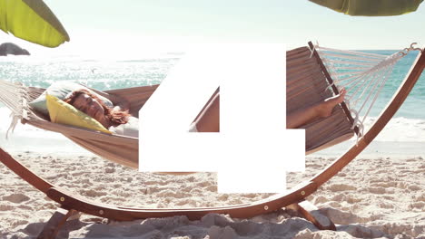 large number 5 animation over woman relaxing in hammock on sandy beach