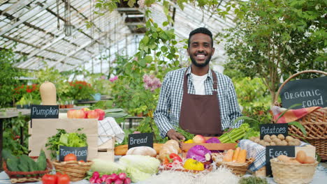 smiling farmer selling fresh produce at a greenhouse market