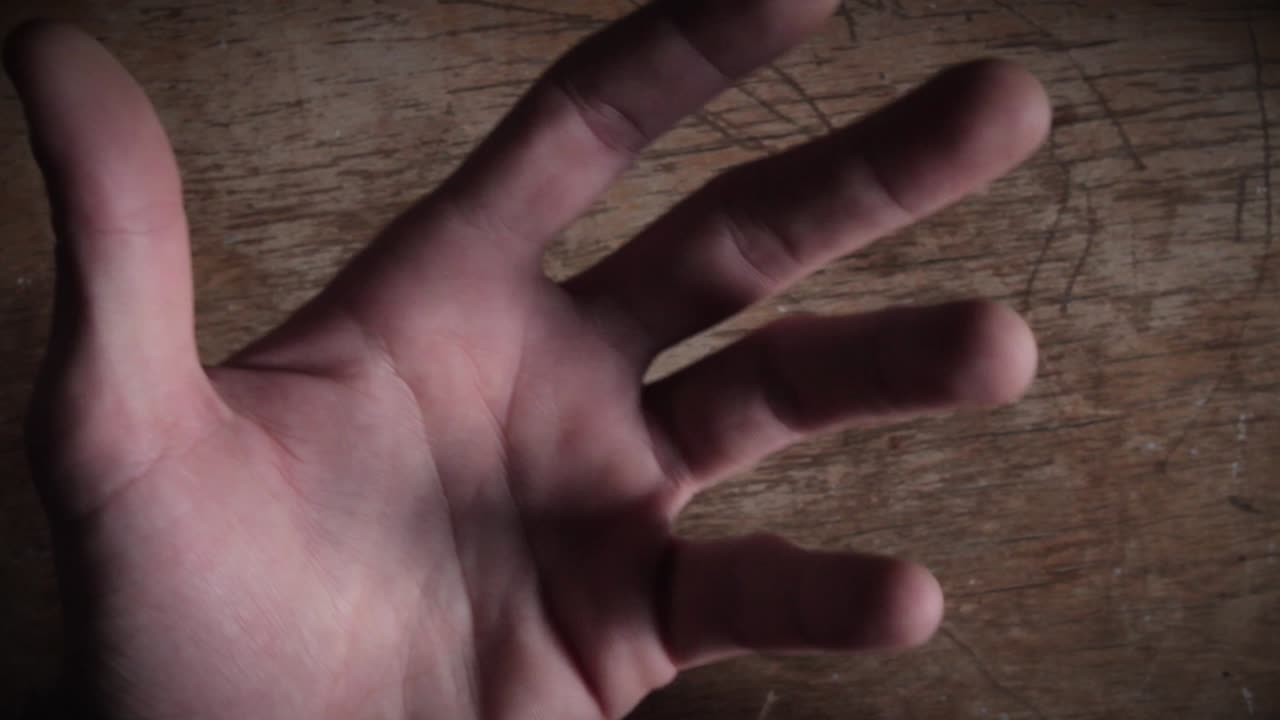 나무 표면에서 표현적인 움직임을 하는 손의 클로즈업