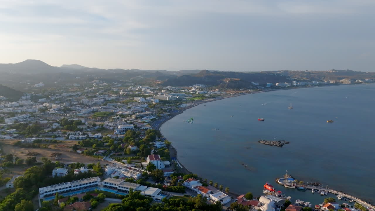 Panoramic drone shot rotating in front of the Faliraki town, sunset in Rhodes