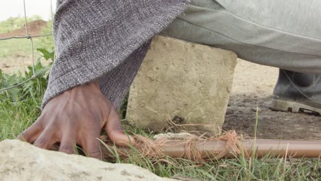 shepherd sitting on a rock and tenderly touching his staff - tracking shot