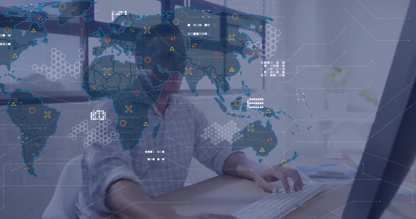 data analyst typing at modern home office, displaying global map overlay with hexagon patterns